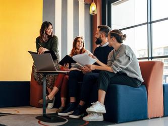 group of people at work chatting in modern office comfortable chairs
